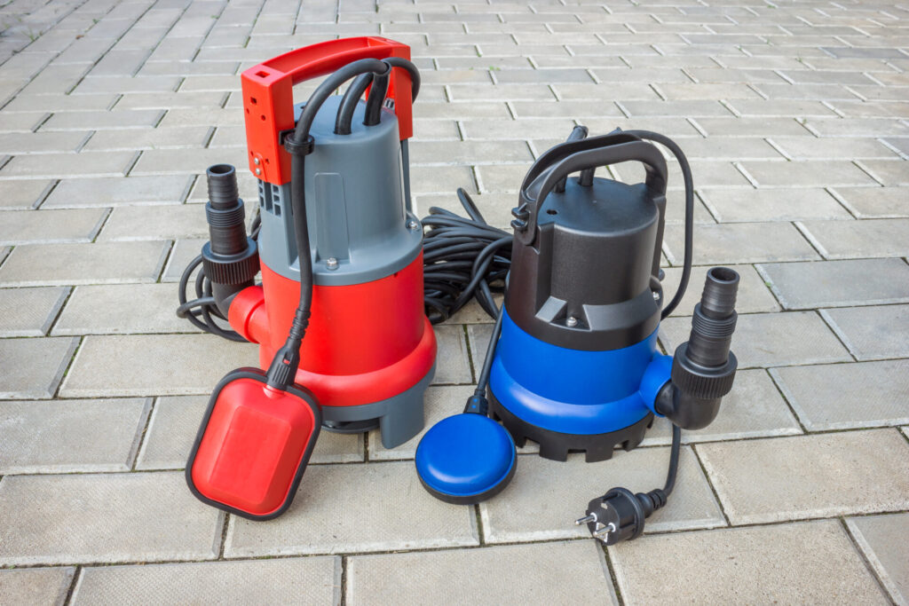 Two household sump pumps on a stone ground. 