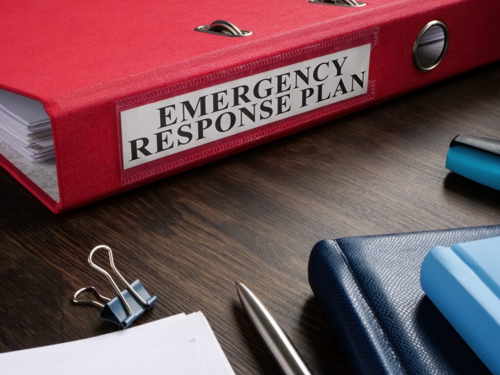 A red binder with a printed Emergency Response Plan label on the spine